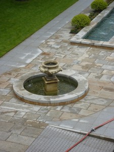 Antique Granite coping around water feature cut on site to fit